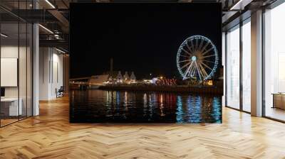 Gdansk, North Poland - August 13, 2020: Night photography of cityscape consisting old town commercial market and illuminated ferries wheel over motlawa river Wall mural