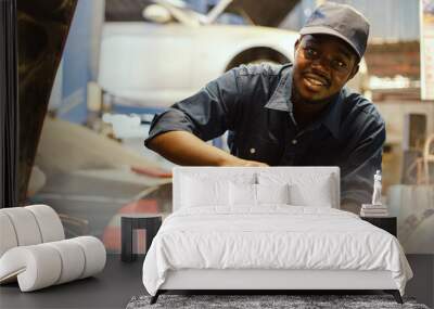 African auto mechanic inspects a car that has a problem with overheating causing smoke Wall mural