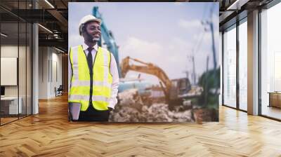 African engineer man or architect checking construction with white safety helmet in construction site. Standing at highway concrete road site Wall mural