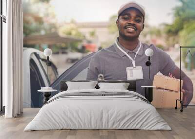 African male postal delivery courier man holding delivering package boxs and cardboard Wall mural