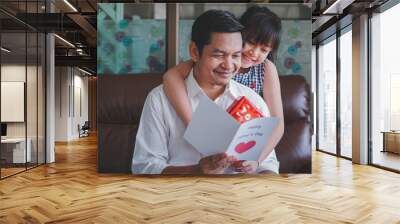 asian little child daughters congratulating dad and giving him postcard and gift box with smiling an Wall mural