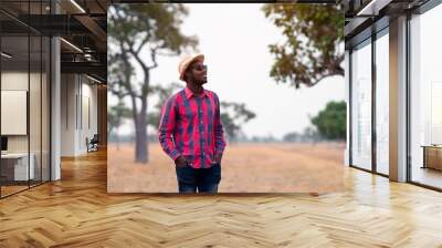 Portrait of african traveler smiling and enjoying his recreation time in nature.Concept of tourism day Wall mural