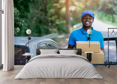 Smile african male postal delivery courier man in the car delivering package Wall mural