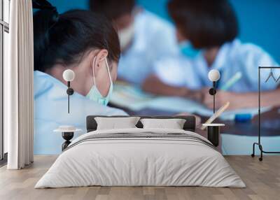 Uniform students wearing hygienic mask while studying in the classroom Wall mural