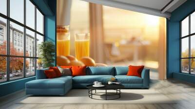 A refreshing morning scene featuring orange juice and oranges by a window, illuminated by soft sunlight. Wall mural