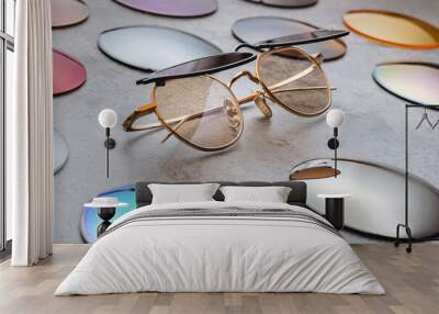 Assortment of different multicolored lenses for eyewear, fashion trendy sunglasses with changeable lenses lying on table in professional optical shop. Optician technician and eyesight concept  Wall mural