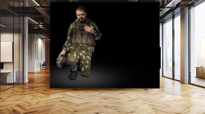 Military man praying on black background Wall mural