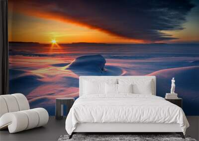 Snowy seascape with dark cloud and rising sun Wall mural