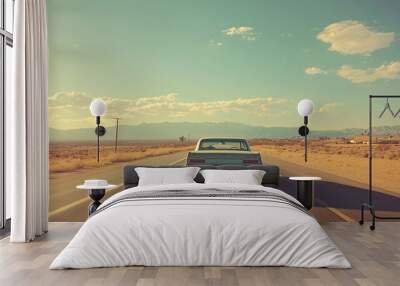 A vintage car drives along a deserted highway under a clear sky, evoking a sense of adventure and freedom. Wall mural