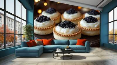 Six small pastry tartlets with creamy white filling topped with black caviar. Wall mural