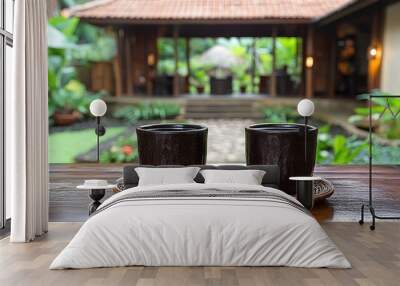 Two ceramic cups on a wooden table with a tropical villa in the background. Wall mural