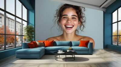 Beauty portrait of happy attractive young woman with glowing healthy radiant pure skin and beautiful hair. Pretty european girl model smiling on background advertising skin care cosmetic. Closeup face Wall mural