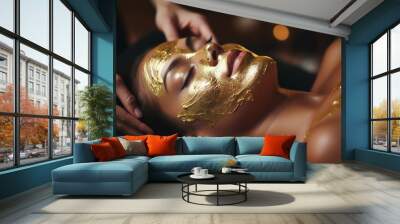 Cosmetologist creating gold foil face mask for woman's spa treatment Wall mural