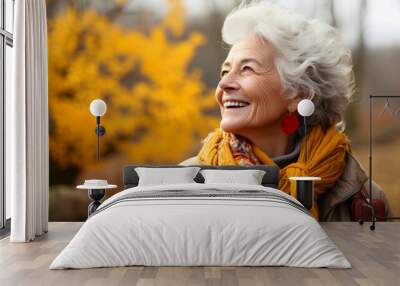 Portrait of an elderly happy smiling woman in autumn park, positive cheerful aged lady enjoying a walk outdoors in autumn forest Wall mural