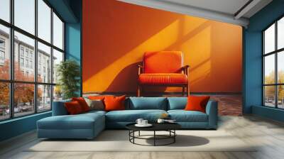 A chair is sitting in front of a wall with a bright orange color Wall mural