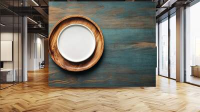 A white plate sits on a wooden table Wall mural