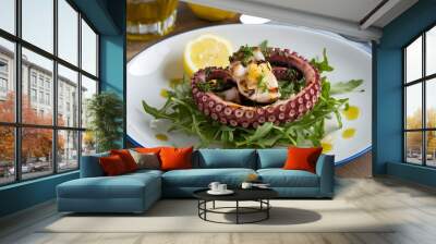 A plate of grilled octopus with lemon and herbs, served over a bed of arugula and garnished with a drizzle of olive oil.   Wall mural