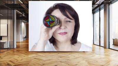 Adult woman looking into a kaleidoscope Wall mural