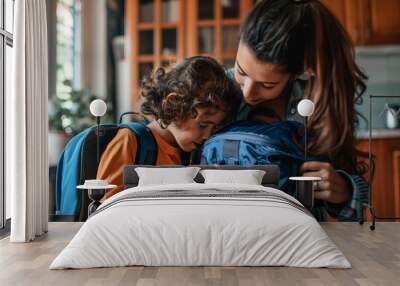 A mother helping her child pack a backpack for the first day of school. spring, motherood moments, preparing for school Wall mural