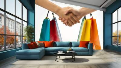 two people shaking hands, with each person holding several colorful shopping bags. The background is plain white, which highlights the handshake and the bags, symbolizing a successful transaction Wall mural