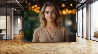 Half body shot of an Australian woman with shoulder-length blonde hair, wearing a beige blouse, standing on a deck with Christmas lights and garland, holding a holiday card, copy space, festive Wall mural