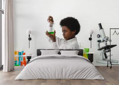 African american cute little boy student child learning research and doing a chemical experiment while making analyzing and mixing liquid in glass at science class on the table.Education Wall mural