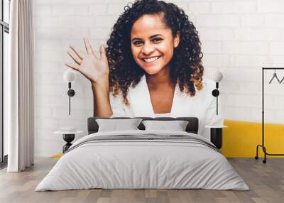 Beautiful african american black woman smiling at camera waving and saying hello to you Wall mural