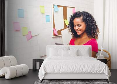 Beautiful creative business african american black woman planning and thinking over the project writing on stickers note at modern office Wall mural