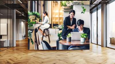 Group of asian business discussing meeting strategy sharing ideas thoughts with project.Creative business people working with laptop computer in green plant terrace decorated modern workloft Wall mural