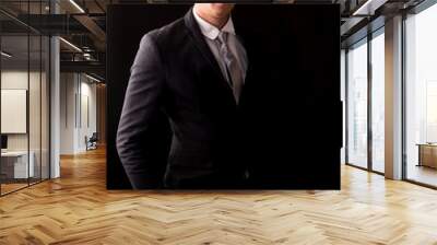 Handsome Businessman with black suit isolated on black background Wall mural