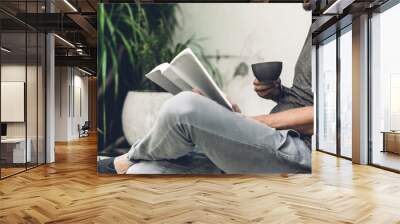 Handsome hipster man relaxing read the paper book work study and looking at page magazine while sitting on chair in cafe and restaurant Wall mural