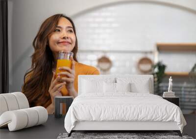 Portrait of beauty body slim healthy asian woman drinking glass of juice and orange.young girl preparing cooking healthy drink with fresh orange juice in kitchen at home.Diet concept.healthy drink Wall mural