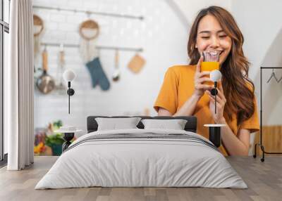 Portrait of beauty body slim healthy asian woman drinking glass of juice and orange.young girl preparing cooking healthy drink with fresh orange juice in kitchen at home.Diet concept.healthy drink Wall mural