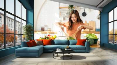 Portrait of beauty body slim healthy asian woman having fun cooking and preparing cooking vegan food healthy eat with fresh vegetable salad in kitchen at home.Diet concept.Fitness and healthy food Wall mural