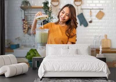 Portrait of beauty healthy asian woman making green vegetables detox cleanse and green fruit smoothie with blender.young girl drinking glass of smoothie, fiber, chlorophyll in kitchen.Diet, healthy Wall mural