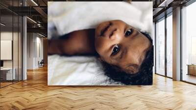 Portrait of cute adorable little african american baby looking at camara in a white bedroom Wall mural