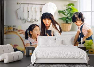 Portrait of enjoy happy love asian family mother and little asian girl daughter child having fun help cooking food healthy eat together with fresh vegetable salad and sandwich ingredient in kitchen Wall mural