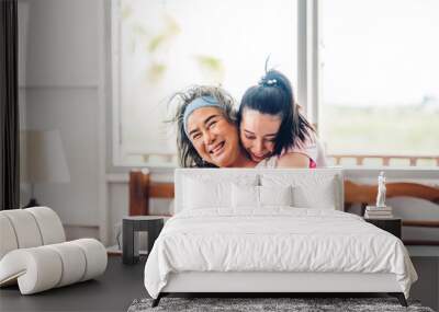 Portrait of enjoy happy love asian family senior mature mother and young daughter smiling laughing embracing and having fun hug together in moments good time at home Wall mural