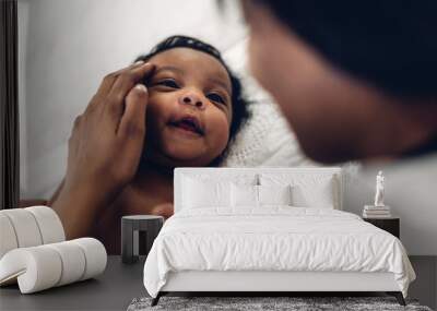 Portrait of enjoy happy love family african american mother playing with adorable little african american baby.Mom kiss with cute son moments good time in a white bedroom.Love of black family Wall mural