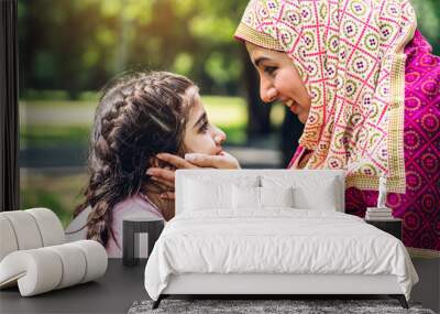 Portrait of religious enjoy happy love asian family arabic muslim mother and little muslim girls child with hijab dress smiling and having fun touching face with cute kid daughter moments good time Wall mural