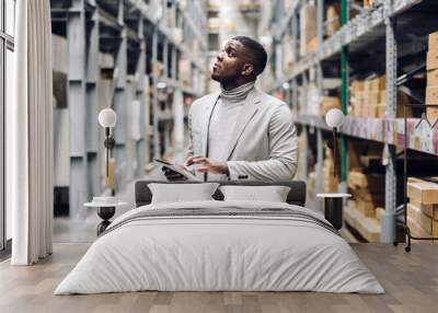 portrait of smiling african american business man order details on tablet checking goods and supplie Wall mural