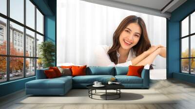 Portrait of smiling cheerful beautiful pretty asian woman clean fresh healthy white skin posing smile in pajamas white clothes.Girl felling relax and enjoy time on the bed at home.asia beauty Wall mural