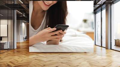 Portrait of smiling happy beauty asian woman relax using digital technology smartphone.Young asian girl looking at mobile phone screen typing message and playing game online or social media at home Wall mural