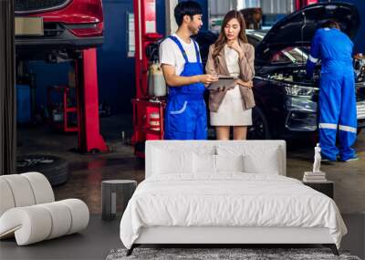 Professional car technician mechanic in uniform work fixing vehicle car engine and maintenance repairing show car report to customer in auto service. Automobile customer service garage Wall mural