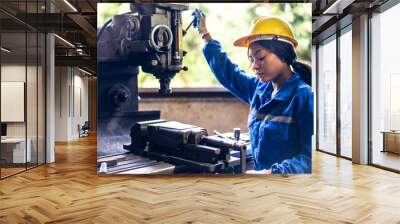 Professional labor machanic engineer technician worker industrial african black woman wearing blue safety uniform working control with heavy machine in manufacturing  factory production line.industry Wall mural