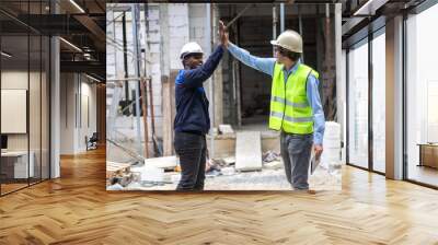 Professional of team architect industrial engineer in helmet working new construction project architectural plan with blueprint and construction tool on table at the building construction site Wall mural