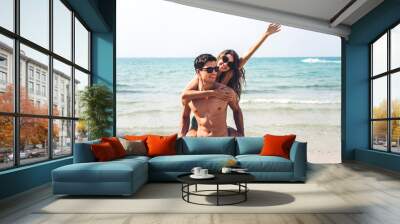 Romantic lovers young couple relaxing together on the tropical beach.Man hugging with woman and enjoy life.Summer vacations Wall mural