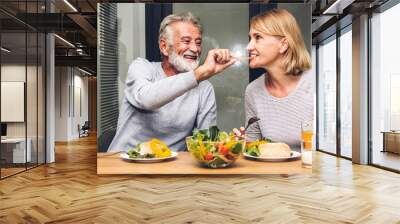 Senior couple enjoy eating  healthy breakfast together in the kitchen.Retirement couple concept Wall mural