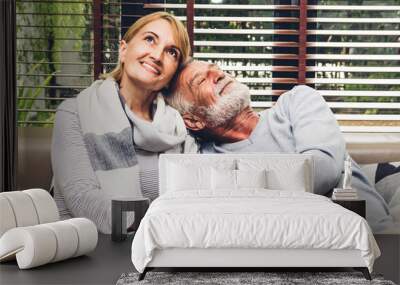 Senior couple relaxing and talking together sitting on sofa in living room at home.Retirement couple concept Wall mural