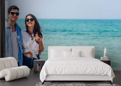 Vacation romantic lovers young happy couple holding hands walking on sand by sea having fun and relaxing together with copy space banner for adding text on tropical beach.Summer vacations and travel Wall mural